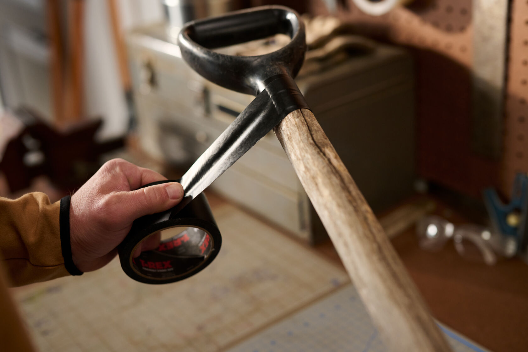 A man repairing the handle of his shovel with Black T-Rex Tape