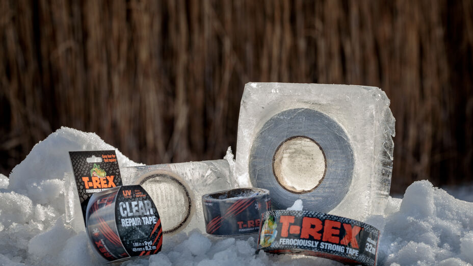 A few rolls of T-Rex Tape in the snow, Two of the five rolls are frozen in ice.