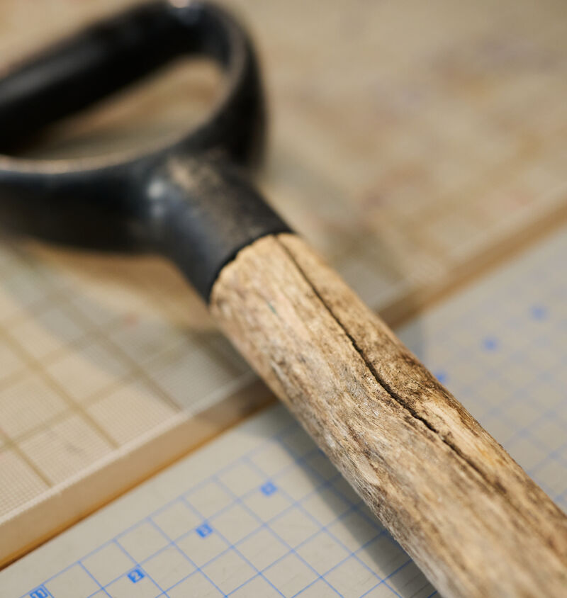 A shovel with a cracked wooden handle