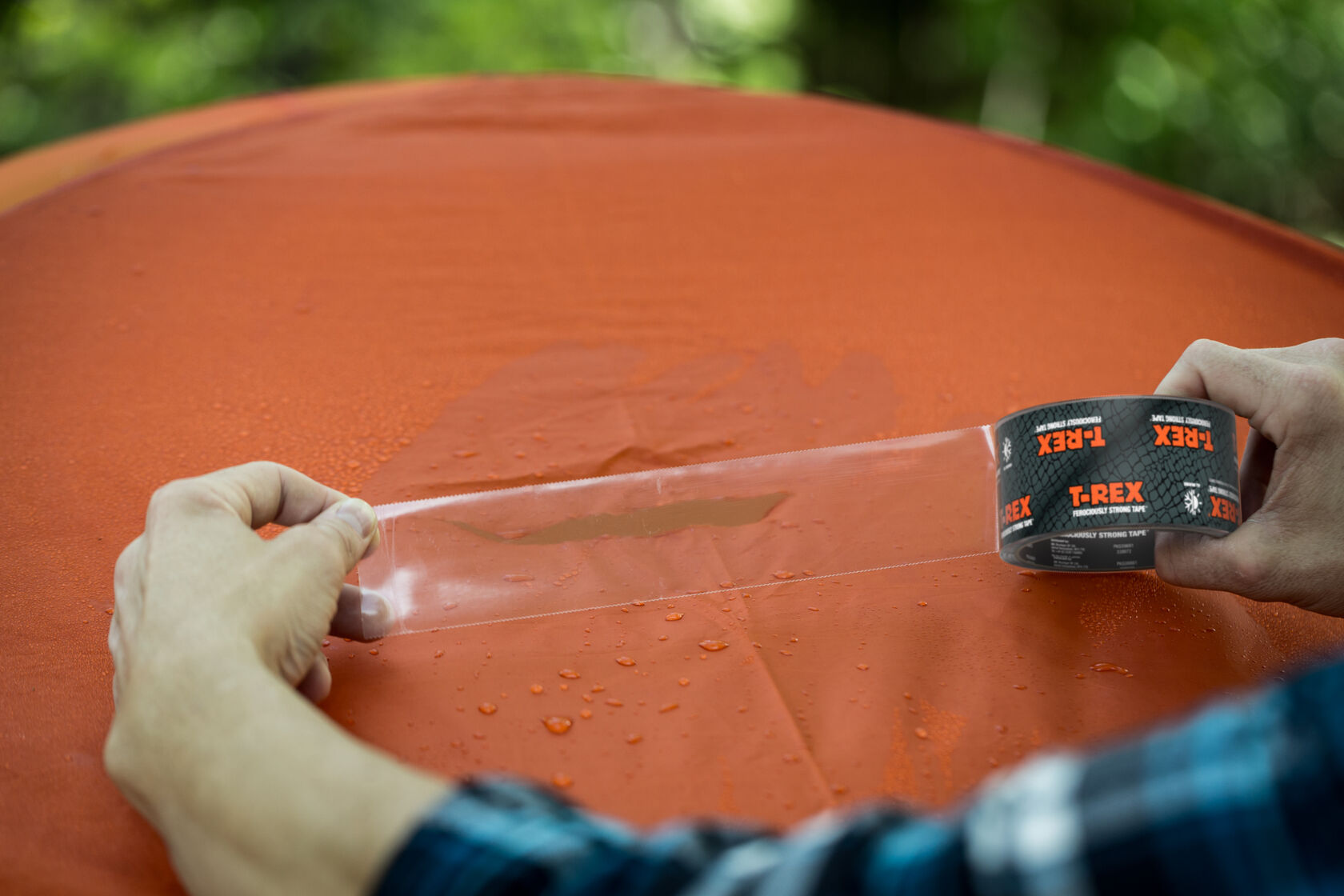 Clear T-Rex Repair Tape, fixing a tear in an orange tent