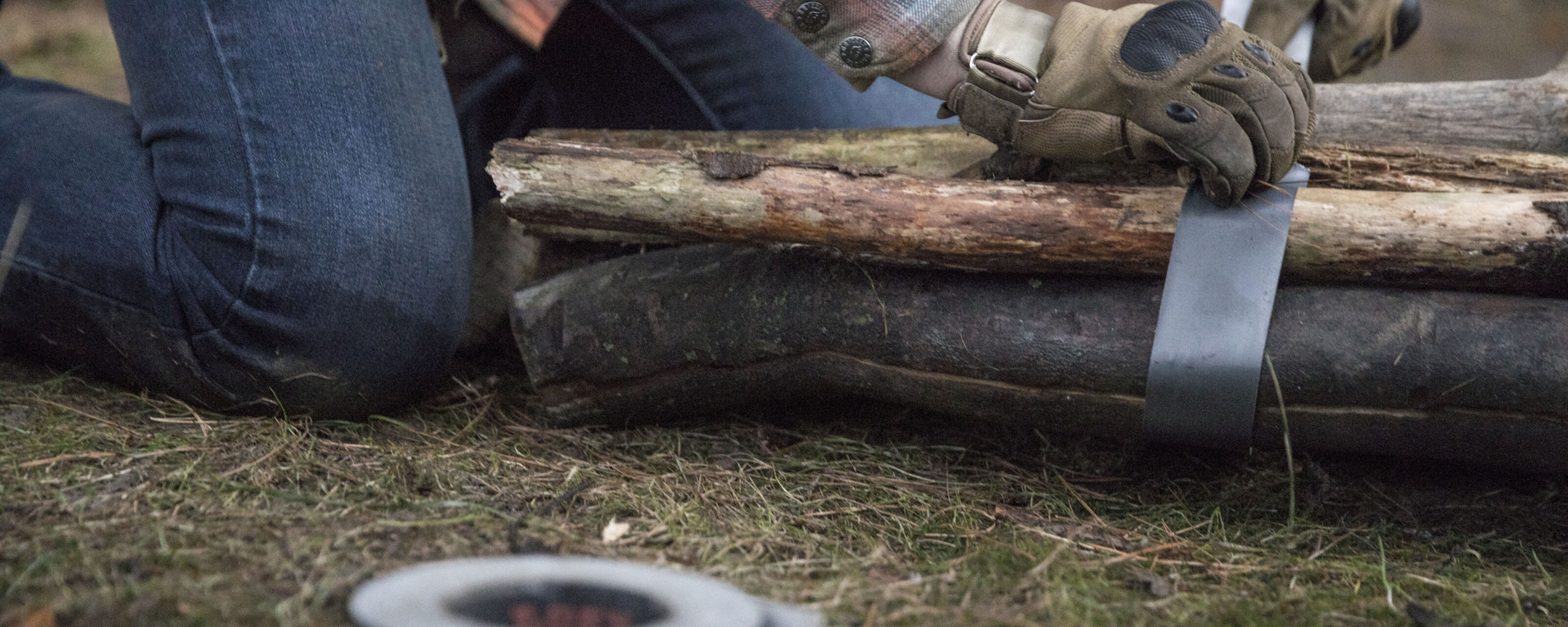 A person using T-Rex Duct Tape to bundle branches