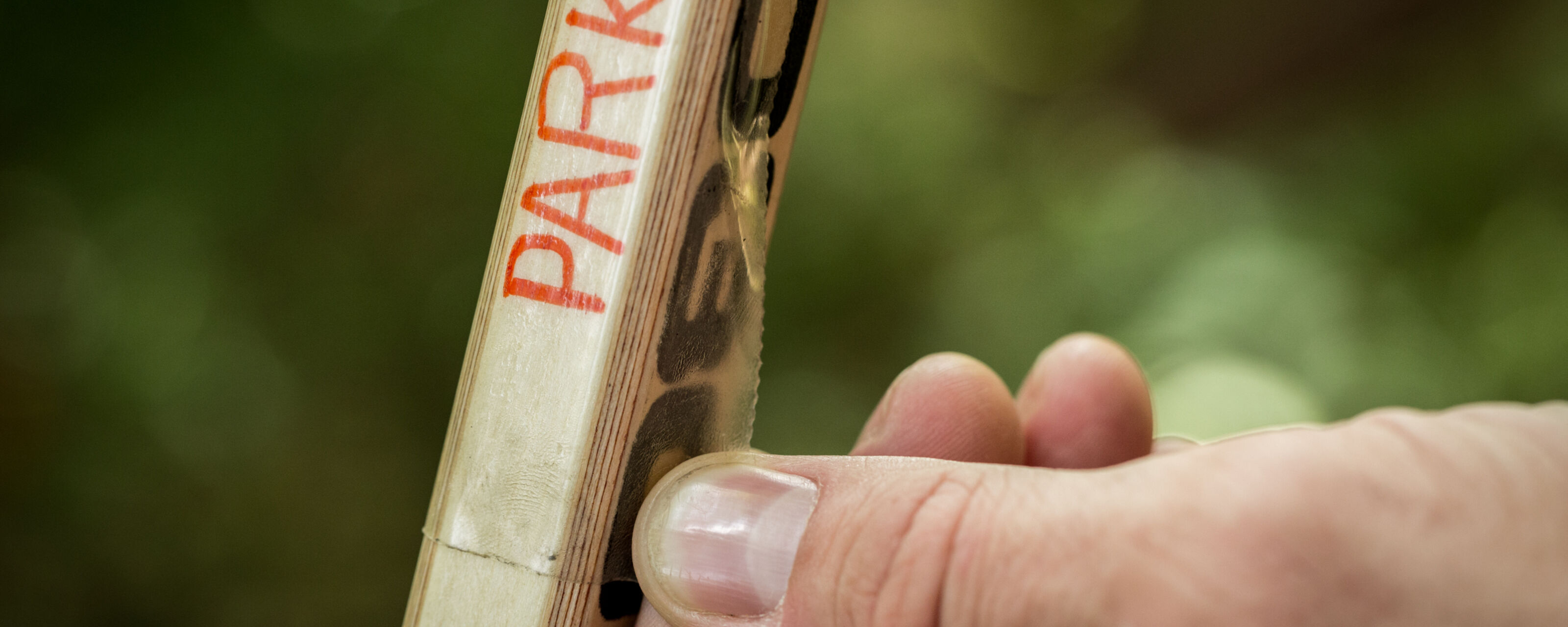 A piece of clear T-Rex Tape being used to label a Hockey Stick
